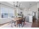 Bright dining room with a modern chandelier, wood table, and an adjacent kitchen with a breakfast bar at 16566 Branham Dr, Fishers, IN 46040