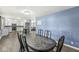 Open dining room has hardwood floors and a blue accent wall connecting to a spacious kitchen with white cabinets at 1710 Bittersweet Dr, Anderson, IN 46011