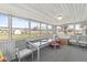 Enclosed sunroom with multiple windows and carpeted floor offering a view of the backyard and open field at 1710 Bittersweet Dr, Anderson, IN 46011