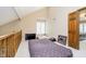 This loft bedroom features neutral walls, carpeted floors, and a window with white plantation shutters at 2005 Dakota Dr, Noblesville, IN 46062