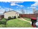 This shows a detached garage with a small yard and path leading to the door as well as a grill to the side at 2023 Shelby St, Indianapolis, IN 46203