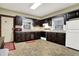 Efficient kitchen with dark wooden cabinets, a white fridge, and ample counter space for meal preparation at 2023 Shelby St, Indianapolis, IN 46203