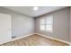 Cozy bedroom featuring hardwood floors, neutral walls, and a bright window at 220 Monroe St, Indianapolis, IN 46229
