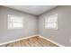 Well-lit bedroom featuring hardwood floors, neutral walls, and two bright windows at 220 Monroe St, Indianapolis, IN 46229