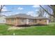 Exterior shot of a stone home featuring new roof, green lawn and manicured landscaping at 220 Monroe St, Indianapolis, IN 46229