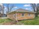 Side view of home featuring a brick exterior, well-maintained lawn, and seamless gutters at 220 Monroe St, Indianapolis, IN 46229