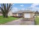 Charming single-story home boasts a stone facade, attached garage, and inviting curb appeal at 220 Monroe St, Indianapolis, IN 46229