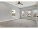The primary bedroom is spacious with a ceiling fan, neutral carpet and three large windows at 2352 N College Ave, Indianapolis, IN 46205