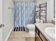 Standard bathroom featuring neutral tiling, a toilet, a shower with a colorful curtain, and a storage shelf at 2468 Shadow Bend Dr, Columbus, IN 47201