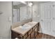 Bathroom featuring double sinks, wood-look floors, and ample storage at 2468 Shadow Bend Dr, Columbus, IN 47201