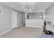 Carpeted bonus room with hanging chandelier, window and view of a door at 2468 Shadow Bend Dr, Columbus, IN 47201