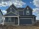 New two-story home with blue siding, stone accents, an attached two-car garage, and a covered front porch at 2634 Penn Ave, Plainfield, IN 46168