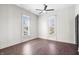 A bedroom featuring hardwood floors, a ceiling fan, and two windows providing natural light at 2748 Carrollton Ave, Indianapolis, IN 46205