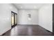 Bright, empty room with hardwood floors and double glass doors leading outside at 2748 Carrollton Ave, Indianapolis, IN 46205