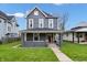 Charming home with a covered porch, well-maintained lawn, and mature trees in a residential neighborhood at 2748 Carrollton Ave, Indianapolis, IN 46205