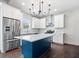 Modern kitchen featuring stainless steel appliances, white cabinets, a blue island, and marble backsplash at 2748 Carrollton Ave, Indianapolis, IN 46205