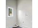 A room with a window, washer hookups, dryer hookups, and flooring at 2748 Carrollton Ave, Indianapolis, IN 46205