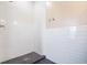 Shower with gray tile floor, and white subway tiled walls with shower head and hooks at 2748 Carrollton Ave, Indianapolis, IN 46205
