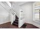 Classic stairway with white banisters, dark wood steps, and natural light from the windows at 2748 Carrollton Ave, Indianapolis, IN 46205