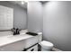Bathroom features a sink with white cabinets, black hardware, a toilet, and gray paint at 305 Beacon Point Ln, Fortville, IN 46040