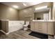 Bathroom featuring a large vanity with double sinks, a soaking tub, and modern fixtures at 305 Beacon Point Ln, Fortville, IN 46040