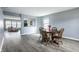 Dining room featuring hardwood floors, a wooden table and chairs, adjacent to living space at 305 Beacon Point Ln, Fortville, IN 46040