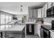 Open-concept kitchen showcasing white cabinets, stainless steel appliances, and stylish island seating at 305 Beacon Point Ln, Fortville, IN 46040