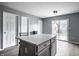 Bright kitchen features a quartz island, gray cabinets, wood floors, and access to the back yard at 305 Beacon Point Ln, Fortville, IN 46040