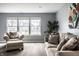 Bright living area featuring large windows, hardwood floors, and comfortable seating, perfect for relaxation at 305 Beacon Point Ln, Fortville, IN 46040