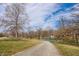Park view with walking path leading to a basketball court and trees under a partly cloudy sky at 305 Beacon Point Ln, Fortville, IN 46040