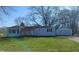 Exterior of a single-story home with an attached garage, front lawn and large trees at 318 Chester St, Anderson, IN 46012