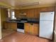 Features wooden cabinets, dark countertops, an oven, and a refrigerator for a functional cooking space at 318 Chester St, Anderson, IN 46012