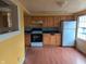 Features wooden cabinets, tile backsplash, and a white refrigerator, offering a functional space for cooking at 318 Chester St, Anderson, IN 46012