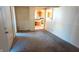 Empty living room featuring neutral walls, carpet, and doorway view to kitchen at 318 Chester St, Anderson, IN 46012