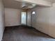 A room with neutral carpet, a white door, and access to another room with diamond patterned window at 318 Chester St, Anderson, IN 46012