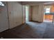 A living room with neutral carpet and white walls, open to the kitchen in the background at 318 Chester St, Anderson, IN 46012