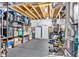 Spacious basement area with exposed ceiling, black flooring, storage shelves, and dual freezers at 3240 Wildlife Trl, Zionsville, IN 46077