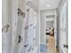 Well-lit bathroom featuring a shower with a butterfly patterned curtain and neutral tile flooring at 3240 Wildlife Trl, Zionsville, IN 46077