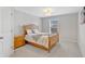 Bright bedroom with neutral walls, carpet, wood bed frame, and bedside table at 3240 Wildlife Trl, Zionsville, IN 46077