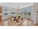 Bright dining room with large windows, hardwood floors, modern chandelier, and wooden dining set at 3240 Wildlife Trl, Zionsville, IN 46077