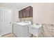 Well-lit laundry room with utility sink, modern appliances, and storage cabinets at 3240 Wildlife Trl, Zionsville, IN 46077