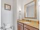 Powder room featuring granite countertops, wood cabinets, and a decorative mirror at 3240 Wildlife Trl, Zionsville, IN 46077