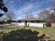 The house has white siding, a brown roof, and a small yard space with a partial fence and some trees at 3314 Argyle Ct, Indianapolis, IN 46226
