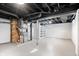 Unfinished basement with exposed ductwork and piping, painted floor and brick chimney at 3445 N Olney St, Indianapolis, IN 46218
