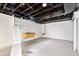 Unfinished basement with white painted walls, open ceiling, and utility sink at 3445 N Olney St, Indianapolis, IN 46218
