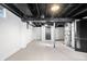 Unfinished basement with exposed ductwork and piping, painted floor, and door at 3445 N Olney St, Indianapolis, IN 46218