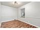 Empty room featuring hardwood floors, neutral walls, a window with blinds, and modern lighting fixtures at 3445 N Olney St, Indianapolis, IN 46218
