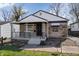 Charming home featuring a covered porch, stone facade, and manicured landscaping at 3445 N Olney St, Indianapolis, IN 46218
