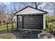 Detached one-car garage with black sliding door and fenced in area at 3445 N Olney St, Indianapolis, IN 46218