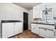 Bright kitchen features white cabinets, black countertops, hardwood floors, and a stainless steel sink at 3445 N Olney St, Indianapolis, IN 46218